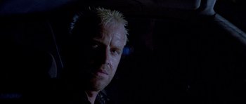 Movie still from “Opera” (1987), directed by Dario Argento – A person wearing a black shirt; Close Up shot, Low angle