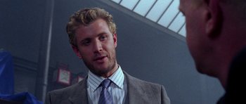 Movie still from “Opera” (1987), directed by Dario Argento – A person wearing a suit and a tie; Close Up shot, Over the shoulder angle