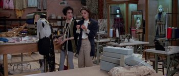 Movie still from “Opera” (1987), directed by Dario Argento – Two women standing next to each other in a room; Medium shot, Over the shoulder angle