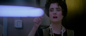Movie still from “Opera” (1987), directed by Dario Argento – A woman is holding a frisbee in her hand; Close Up shot, Low angle