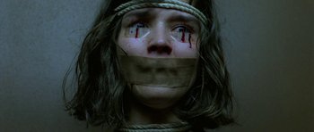 Movie still from “Opera” (1987), directed by Dario Argento – A woman with taped up eyes and mouth; Extreme Close Up shot, Overhead angle