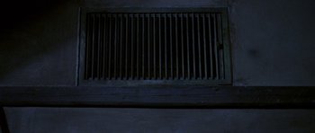 Movie still from “Opera” (1987), directed by Dario Argento – A vent in the middle of a room with a dark background; Extreme Close Up shot, Overhead angle