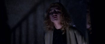 Movie still from “Opera” (1987), directed by Dario Argento – A woman with long blonde curly hair looking up at the sky; Close Up shot, Low angle
