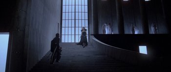 Movie still from “Opera” (1987), directed by Dario Argento – A woman walking down a set of stairs; Wide shot, Low angle