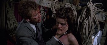 Movie still from “Opera” (1987), directed by Dario Argento – A man and a woman are sitting on a bench; Close Up shot, High angle