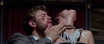 Movie still from “Opera” (1987), directed by Dario Argento – A man and a woman with blood on their face; Close Up shot, Overhead angle