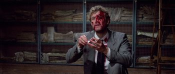 Movie still from “Opera” (1987), directed by Dario Argento – A man in a suit and tie with blood on his face; Close Up shot, High angle