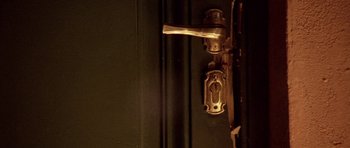 Movie still from “Opera” (1987), directed by Dario Argento – A door handle and a key; Extreme Close Up shot, Overhead angle
