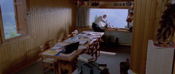 Movie still from “Opera” (1987), directed by Dario Argento – A man standing in front of a long table; Wide shot, High angle