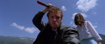 Movie still from “Opera” (1987), directed by Dario Argento – A person holding a knife over their head; Close Up shot, Low angle