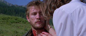 Movie still from “Opera” (1987), directed by Dario Argento – A man with blood on his face and a woman touching his neck; Close Up shot, Low angle
