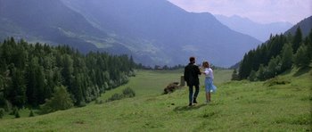 Movie still from “Opera” (1987), directed by Dario Argento – A man and a woman are walking in a field; Extreme Wide shot, High angle