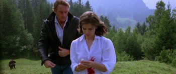 Movie still from “Opera” (1987), directed by Dario Argento – A man and a woman looking at a cell phone; Medium shot, High angle