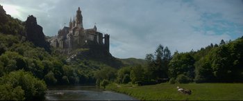 Movie still from “Ophelia” (2018), directed by Claire McCarthy – A castle on top of a hill next to a body of water; Extreme Wide shot, Low angle