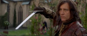 Movie still from “Ophelia” (2018), directed by Claire McCarthy – A man holding a sword in his hand; Medium shot, Over the shoulder angle