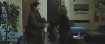 Movie still from “Oranges and Sunshine” (2010), directed by Jim Loach – Two women are shaking hands in front of each other; Medium shot, Over the shoulder angle