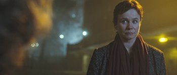 Movie still from “Oranges and Sunshine” (2010), directed by Jim Loach – A man with a scarf standing in front of some lights; Close Up shot, Low angle