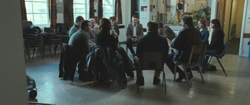 Movie still from “Oranges and Sunshine” (2010), directed by Jim Loach – A group of people sitting in a circle talking; Wide shot, High angle