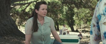 Movie still from “Oranges and Sunshine” (2010), directed by Jim Loach – A woman sitting on top of a bench in a park; Medium shot, Over the shoulder angle