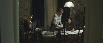 Movie still from “Oranges and Sunshine” (2010), directed by Jim Loach – A man and a woman sitting at a dining room table; Wide shot, High angle