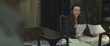 Movie still from “Oranges and Sunshine” (2010), directed by Jim Loach – A woman sitting at a dining room table; Medium shot, High angle