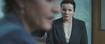 Movie still from “Oranges and Sunshine” (2010), directed by Jim Loach – A woman in a business suit looking at a man in a business suit; Close Up shot, Over the shoulder angle