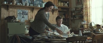 Movie still from “Oranges and Sunshine” (2010), directed by Jim Loach – A man and a woman looking at papers on a table; Medium shot, High angle