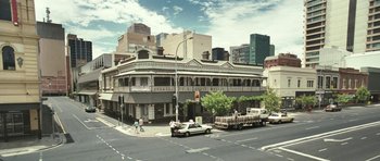 Movie still from “Oranges and Sunshine” (2010), directed by Jim Loach – A street scene with a car parked on the side of the road; Extreme Wide shot, High angle