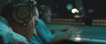 Movie still from “Oranges and Sunshine” (2010), directed by Jim Loach – A man with headphones on sitting in front of a computer screen; Close Up shot, Low angle