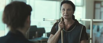 Movie still from “Oranges and Sunshine” (2010), directed by Jim Loach – A woman holding a baseball bat while standing in a room; Close Up shot, Over the shoulder angle