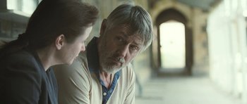 Movie still from “Oranges and Sunshine” (2010), directed by Jim Loach – An older man and a younger woman sitting next to each other in front of a window; Close Up shot, Over the shoulder angle