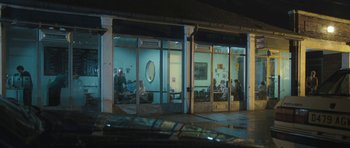 Movie still from “Oranges and Sunshine” (2010), directed by Jim Loach – A group of people sitting in a room next to a building; Wide shot, Over the shoulder angle