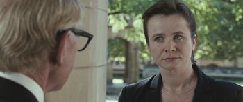 Movie still from “Oranges and Sunshine” (2010), directed by Jim Loach – A woman wearing a black jacket is talking to another woman; Close Up shot, Over the shoulder angle