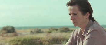 Movie still from “Oranges and Sunshine” (2010), directed by Jim Loach – A woman standing in front of a grassy field; Close Up shot, Low angle