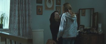 Movie still from “Oranges and Sunshine” (2010), directed by Jim Loach – A woman talking to a young girl in a room; Medium shot, Over the shoulder angle