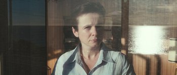 Movie still from “Oranges and Sunshine” (2010), directed by Jim Loach – A woman looking out of a window at the sun; Close Up shot, Low angle