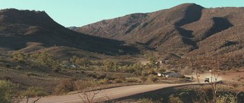 Movie still from “Oranges and Sunshine” (2010), directed by Jim Loach – A dirt road going through the middle of a valley; Extreme Wide shot, High angle