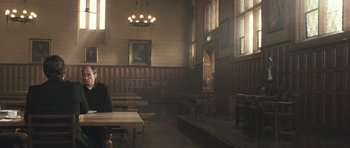 Movie still from “Oranges and Sunshine” (2010), directed by Jim Loach – A room filled with tables and chairs and wooden walls; Wide shot, Low angle