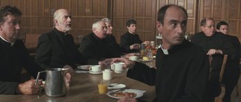 Movie still from “Oranges and Sunshine” (2010), directed by Jim Loach – A group of people sitting at a table with food; Medium shot, Over the shoulder angle