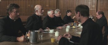 Movie still from “Oranges and Sunshine” (2010), directed by Jim Loach – A group of men sitting at a table with cups of coffee; Medium shot, Over the shoulder angle
