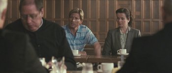 Movie still from “Oranges and Sunshine” (2010), directed by Jim Loach – A man and woman sitting at a table with a cup of coffee; Medium shot, Over the shoulder angle