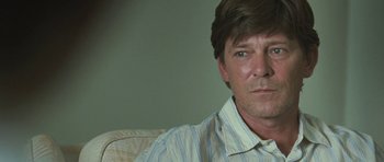 Movie still from “Oranges and Sunshine” (2010), directed by Jim Loach – A person sitting on a couch; Close Up shot, Over the shoulder angle