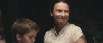 Movie still from “Oranges and Sunshine” (2010), directed by Jim Loach – A person smiling with a child; Close Up shot, Over the shoulder angle