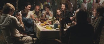 Movie still from “Oranges and Sunshine” (2010), directed by Jim Loach – A group of people sitting around a table eating food; Medium shot, Over the shoulder angle