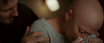 Movie still from “Ordinary Love” (2019), directed by Glenn Leyburn – A man with his hand on his chest; Close Up shot, Over the shoulder angle