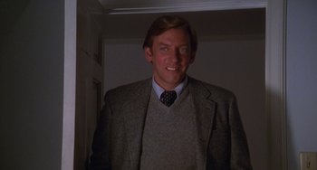 Movie still from “Ordinary People” (1980), directed by Robert Redford – A man in a suit and tie smiling for the camera; Medium shot, Low angle