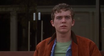Movie still from “Ordinary People” (1980), directed by Robert Redford – A young man wearing a brown jacket looking at the camera; Close Up shot, Over the shoulder angle