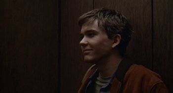 Movie still from “Ordinary People” (1980), directed by Robert Redford – A young man is standing in front of a wooden wall; Close Up shot, Over the shoulder angle