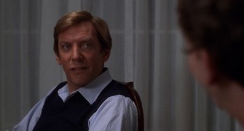 Movie still from “Ordinary People” (1980), directed by Robert Redford – A man in a white shirt and black vest looking at a mirror; Close Up shot, Over the shoulder angle