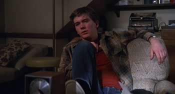 Movie still from “Ordinary People” (1980), directed by Robert Redford – A man sitting on a couch in a living room; Medium shot, High angle
